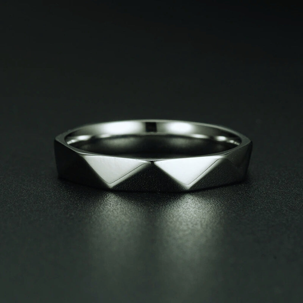 Detalhe dos cortes facetados e do acabamento polido do anel de aço preto Cava.