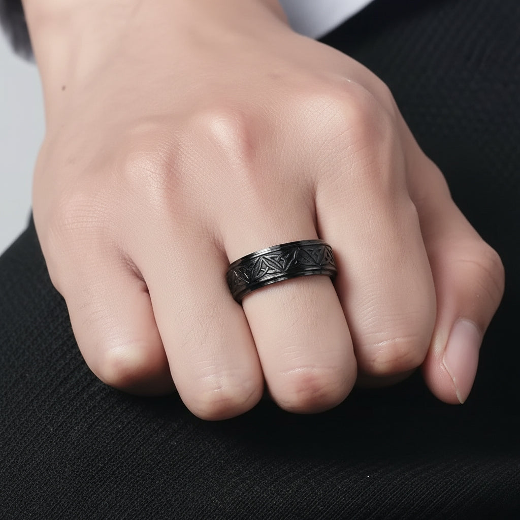 Zoom na mão de Homem usando anel preto com símbolos celtas estilo moderno.