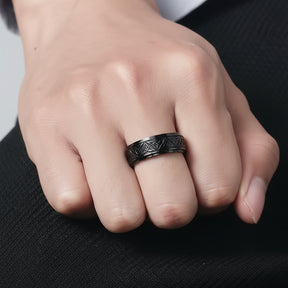 Zoom na mão de Homem usando anel preto com símbolos celtas estilo moderno.