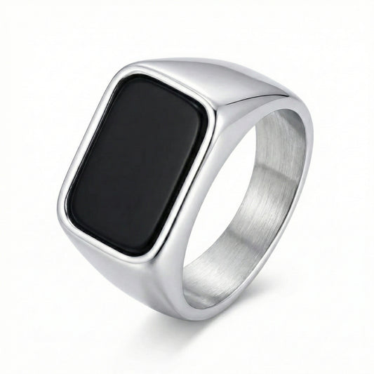 Anel masculino maciço em aço inoxidável prateado com pedra preta retangular, modelo Obsidian da marca Classiatti.