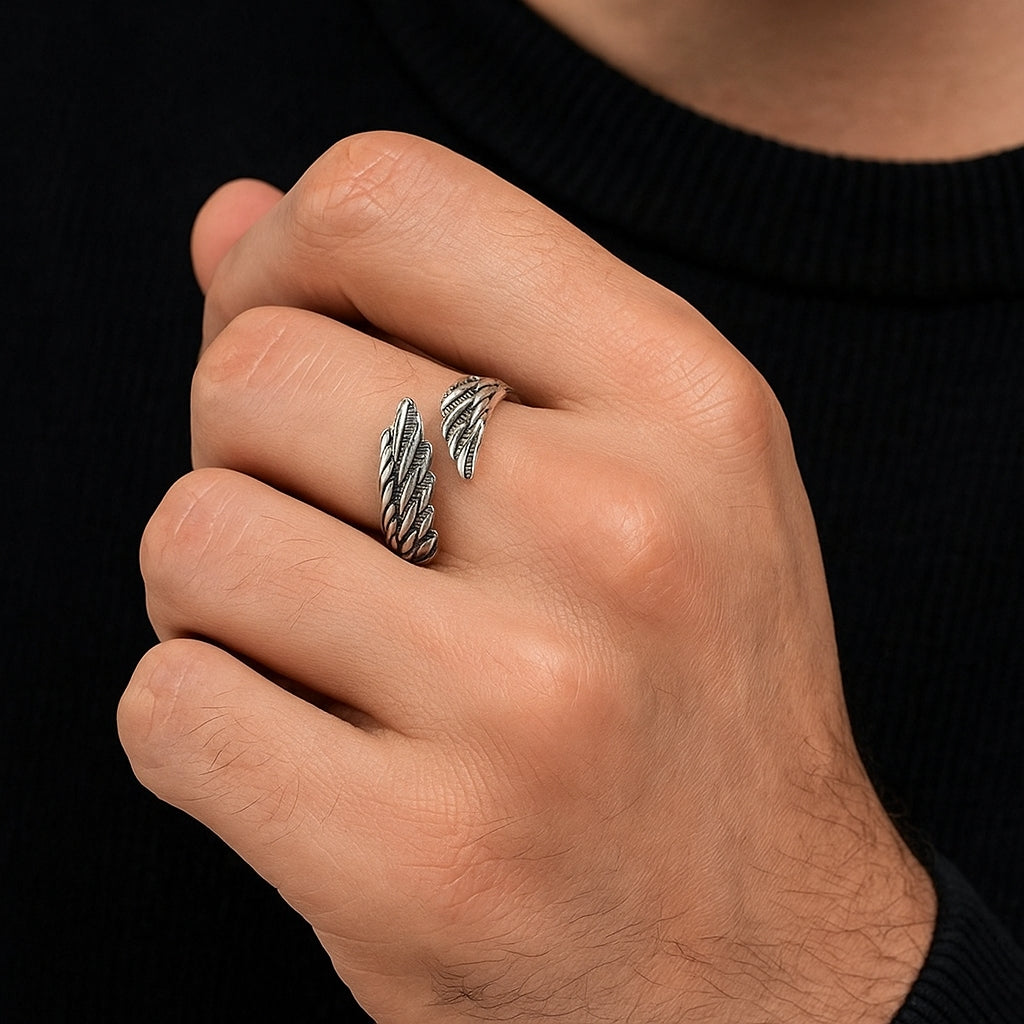 Mão masculina usando o Anel masculino prateado modelo Leivi com design de asas em aço inox
