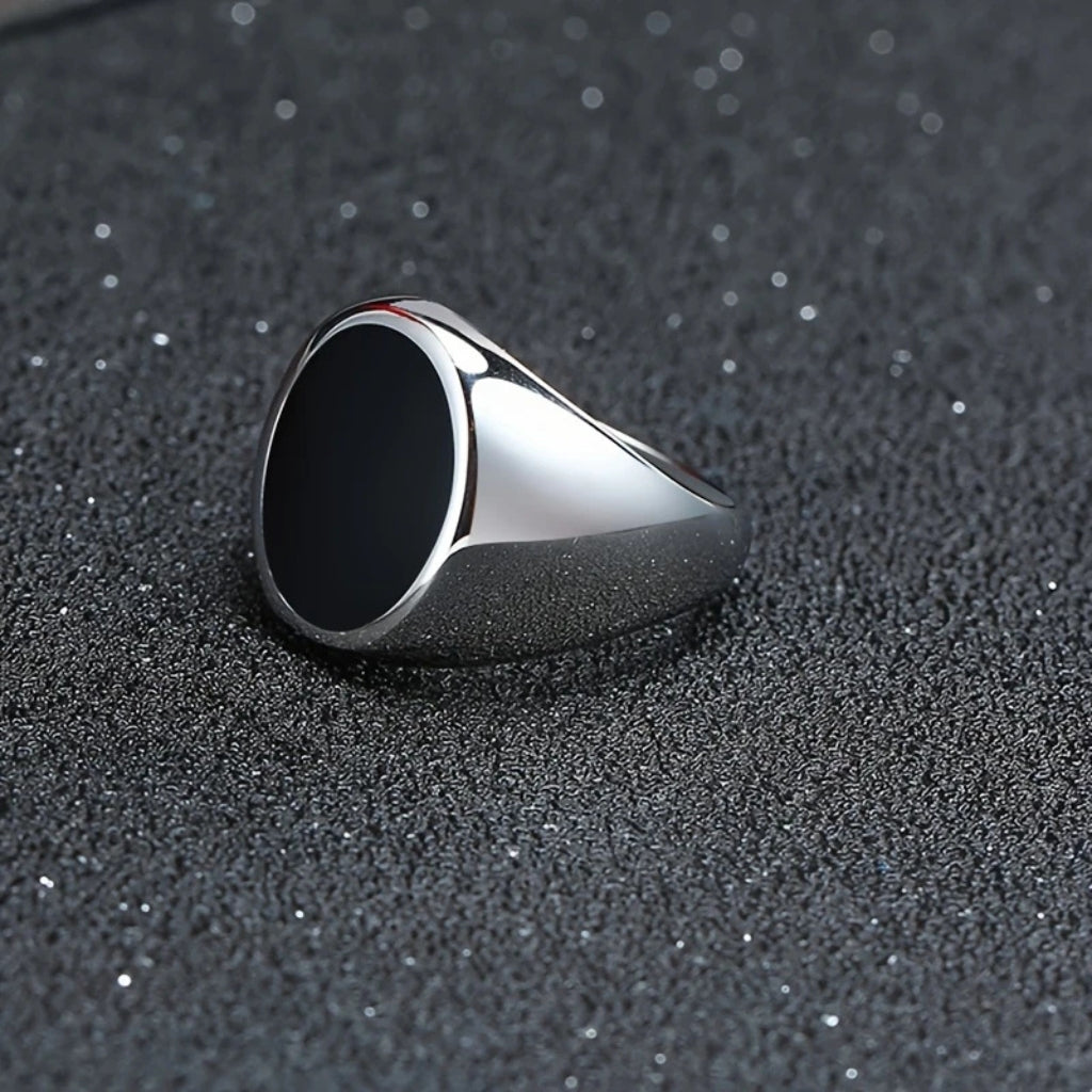 Detalhe do acabamento polido e da pedra escura do anel masculino de aço Varallo.
