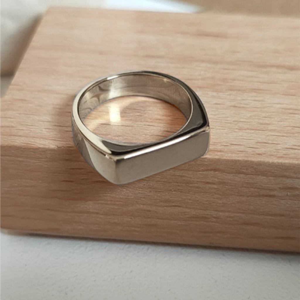 Detalhe do acabamento em aço escovado e topo plano do anel masculino Gavi.