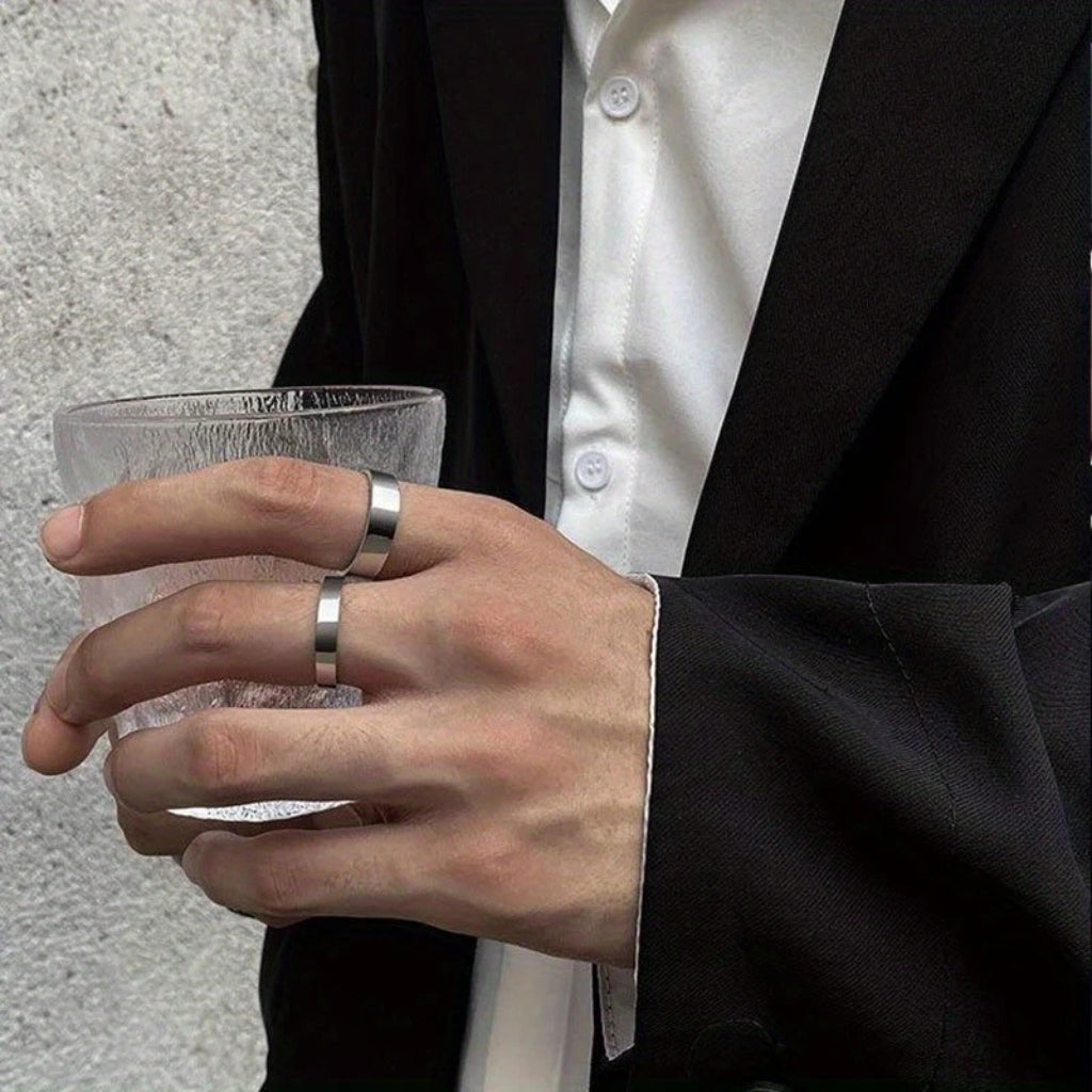 Homem usando anel de banda lisa prateada estilo moderno e discreto.