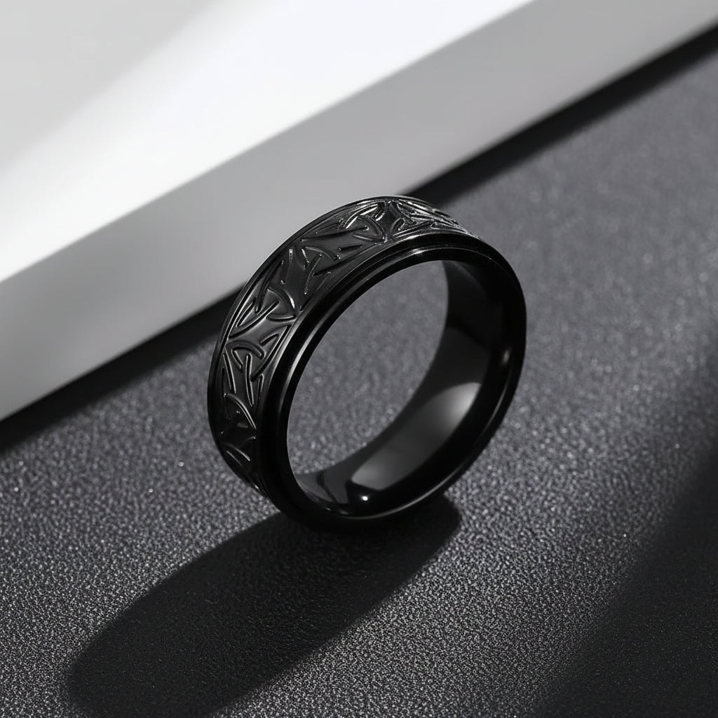 Detalhe da textura de triquetra (nó celta) do anel masculino Riveto Black em pé.