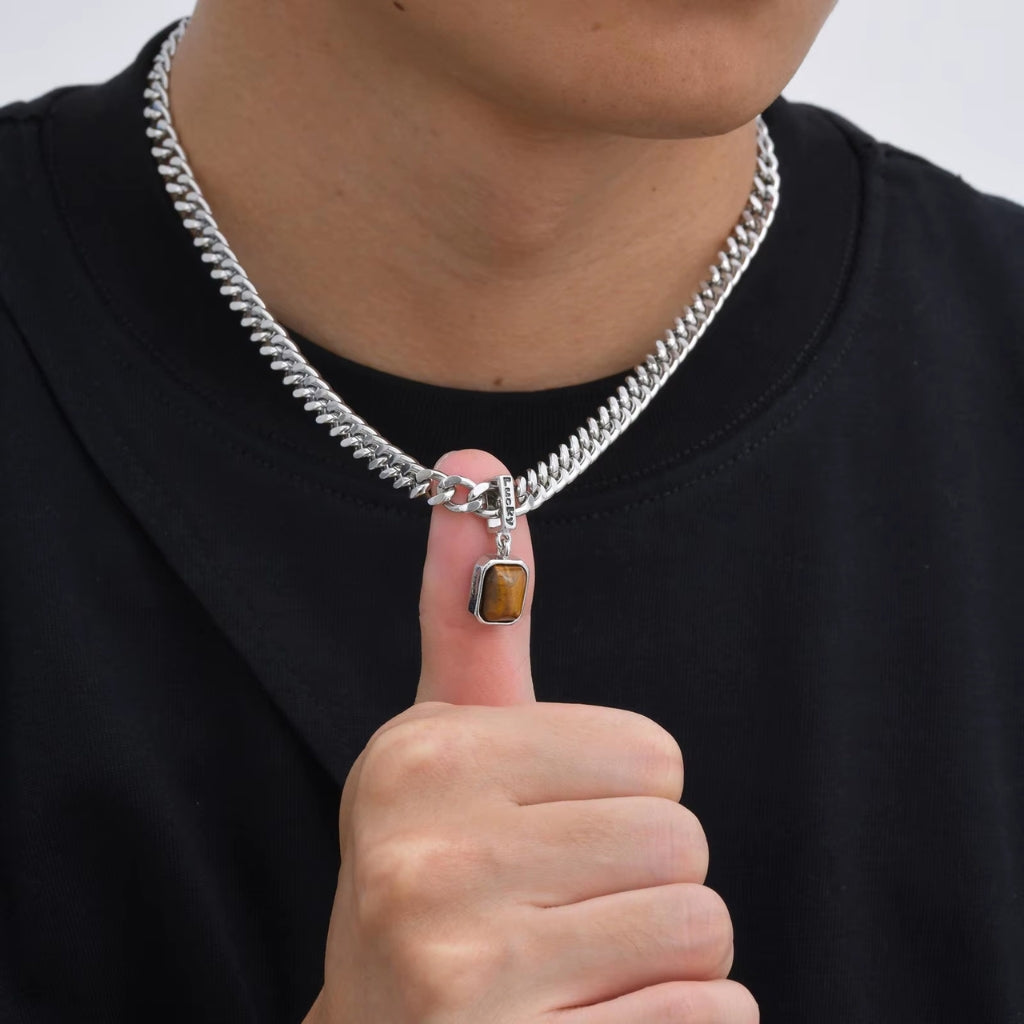 Homem usando colar de corrente prateada grossa com pingente retangular de pedra marrom Lucky.