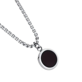 Detalhe do pingente redondo preto com borda prateada do colar masculino Broni.