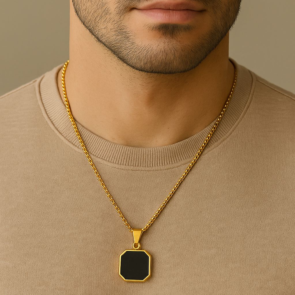 Homem usando colar de corrente dourada com pingente geométrico preto e ouro.