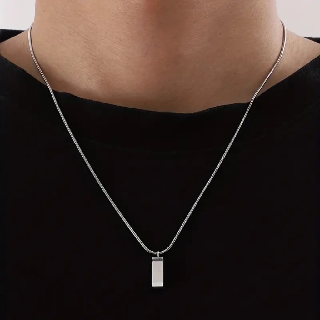 Homem usando colar de corrente fina prateada com pingente geométrico minimalista.