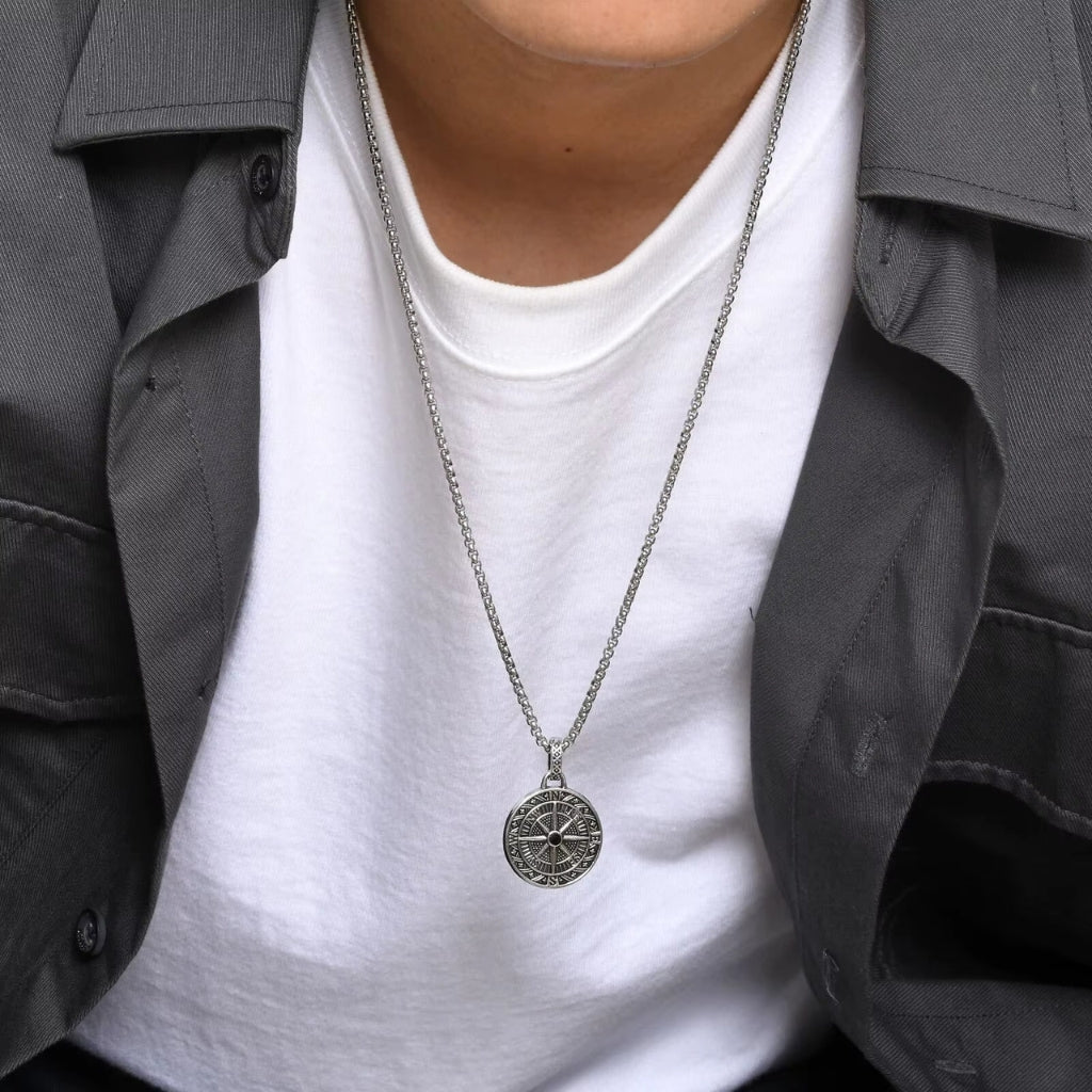 Homem usando colar com pingente de rosa dos ventos estilo vintage na camiseta branca.