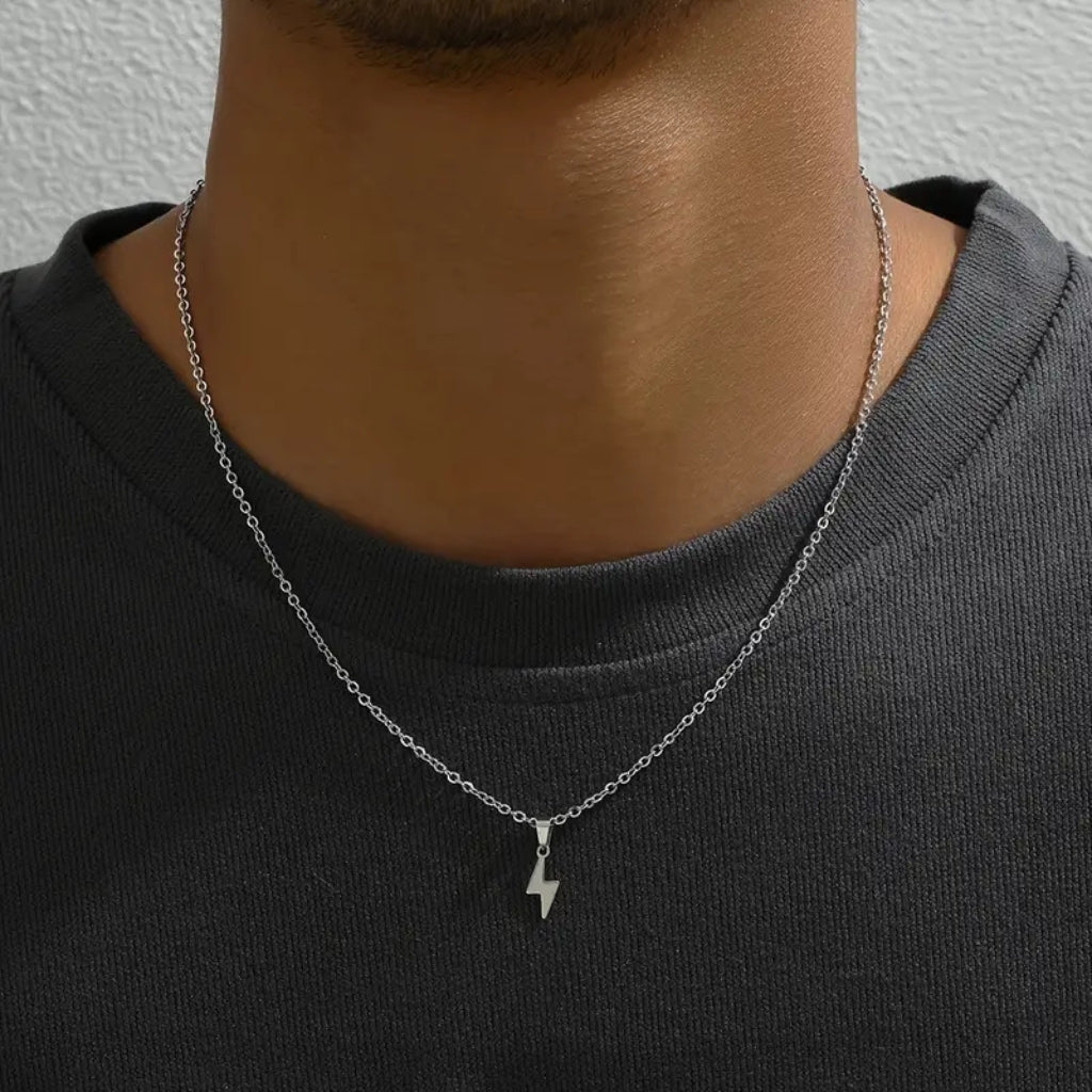 Homem usando colar de corrente fina com pingente de raio (relâmpago) prateado.