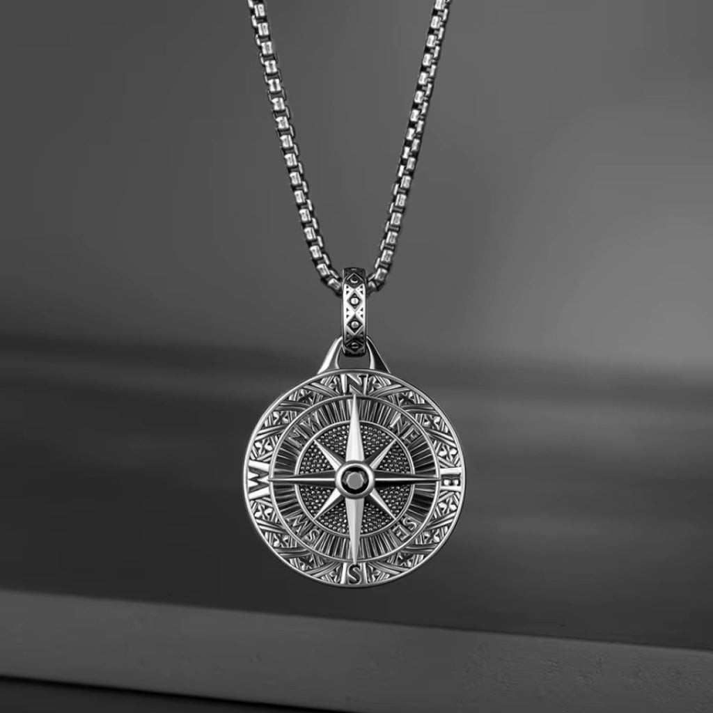 Detalhe da pedra preta central e dos pontos cardeais do colar masculino bússola.