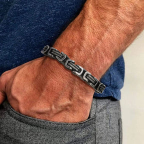 Homem usando a pulseira de aço Grado com elos texturizados envelhecidos, destacando o estilo industrial.