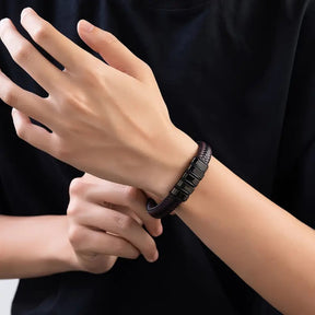 Homem usando pulseira de couro com detalhes em metal preto no pulso.