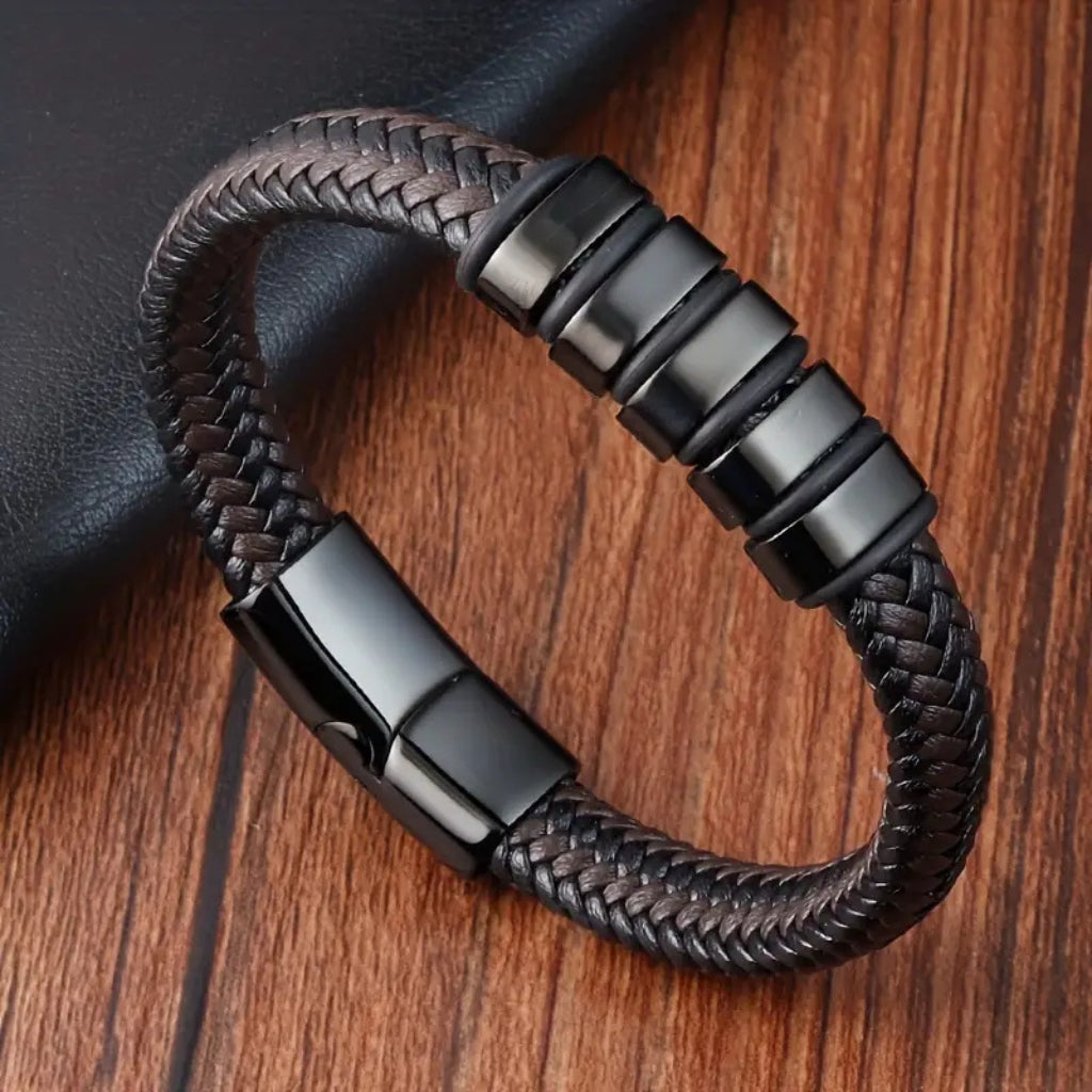 Pulseira de couro marrom trançada masculina com detalhes em aço preto e fecho magnético.