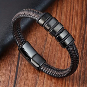 Pulseira de couro marrom trançada masculina com detalhes em aço preto e fecho magnético.
