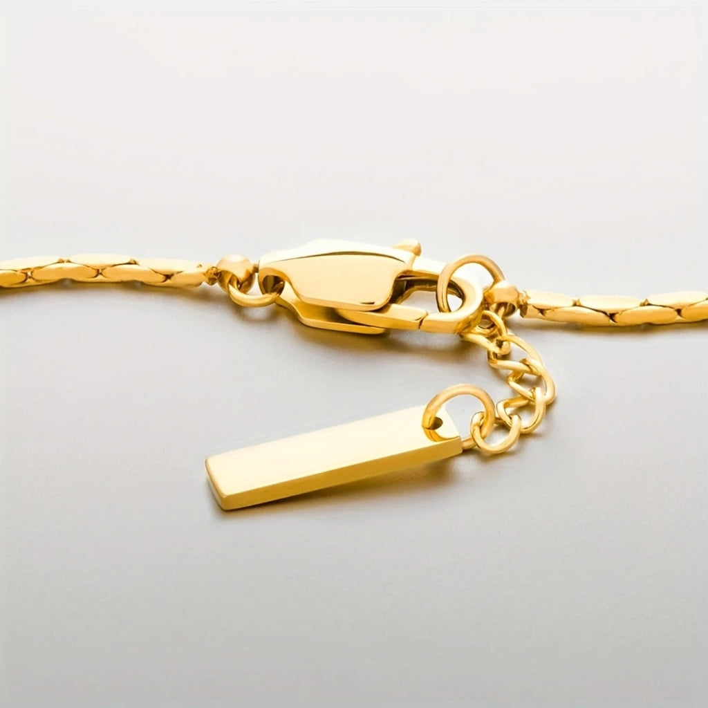 Detalhe do fecho e da plaquinha da pulseira masculina dourada Lusia.