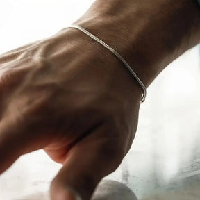 Homem usando pulseira fina de fio redondo prateado (estilo snake) no pulso detalhes