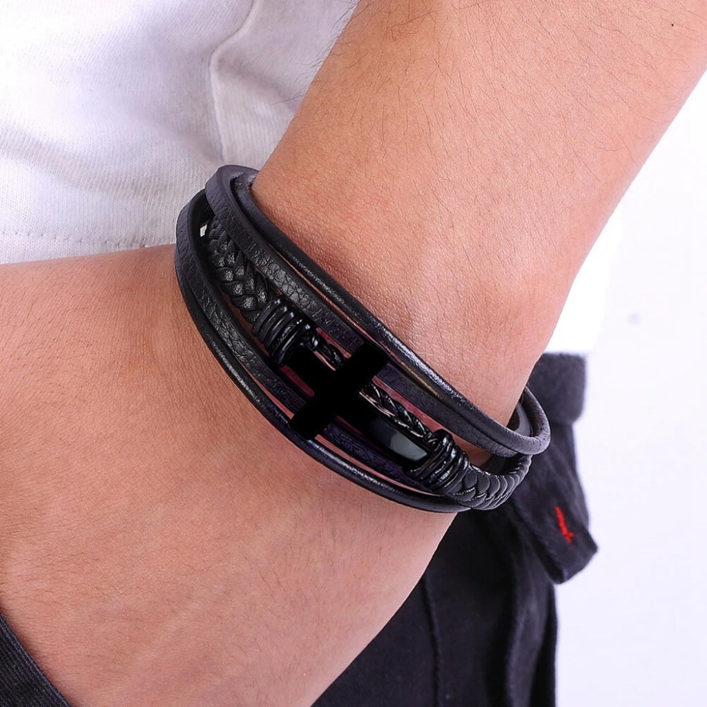 Homem usando pulseira de couro preta com crucifixo estilo moderno.