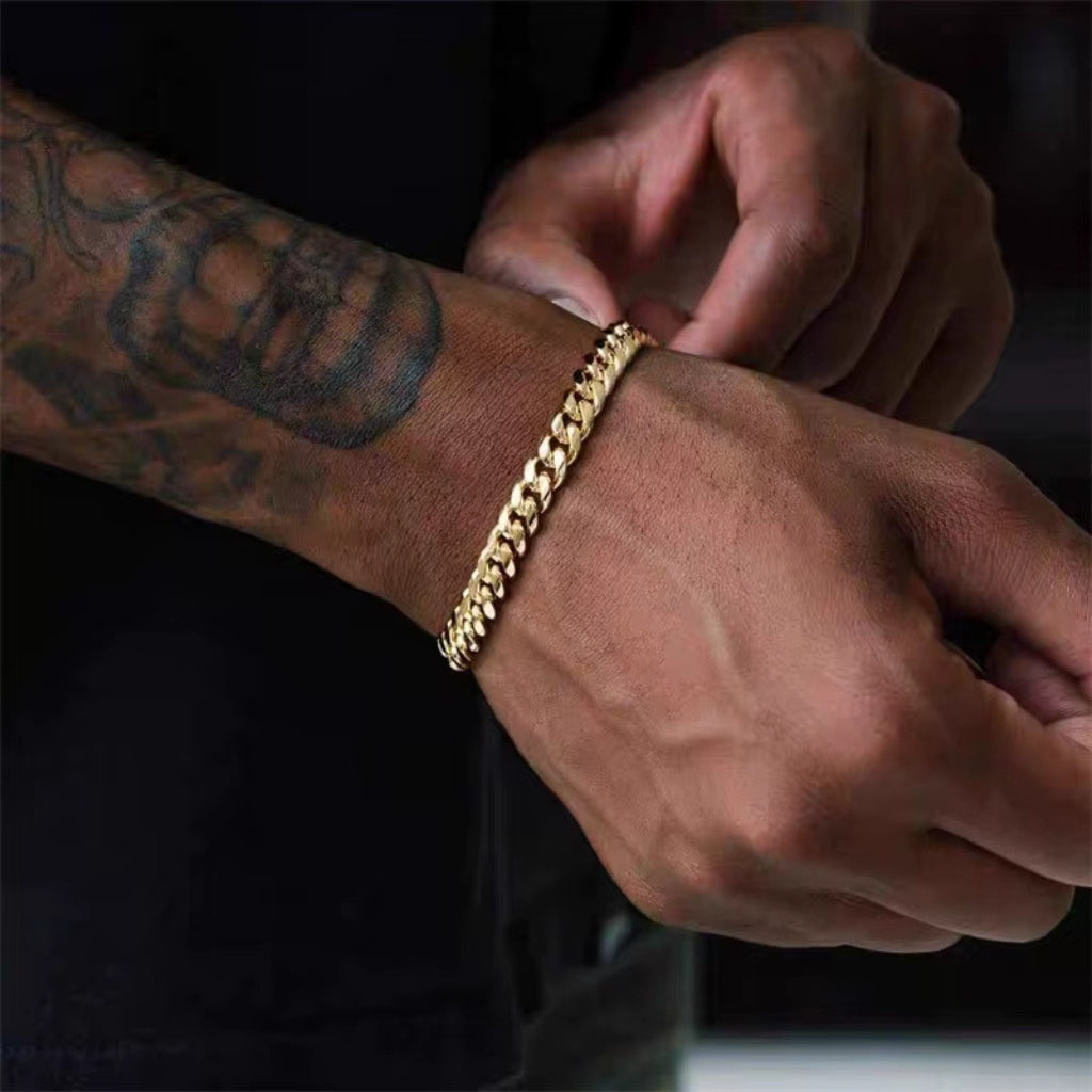 Homem usando pulseira de corrente dourada média estilo clássico no pulso.