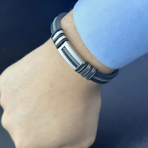 Homem usando pulseira moderna preta e prata estilo tech no braço virado pra cima